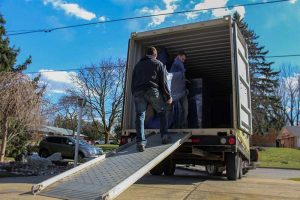two men loading chair into moving container