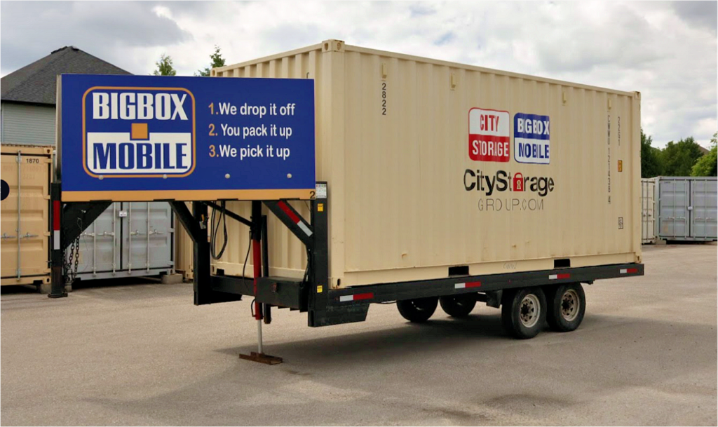 shipping box loaded on trailer ready for delivery. labelled with city storage logos and tag line for big box mobile: 1. we drop it off 2. you pack it up 3. we pick it up