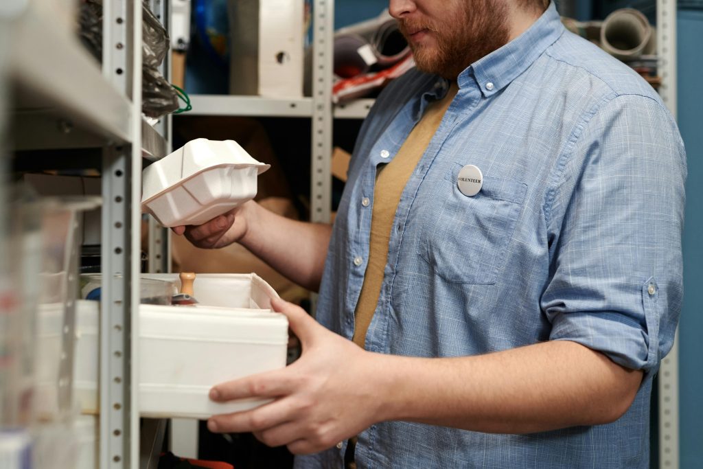 A man choosing merchandise in a crowded stockroom.
