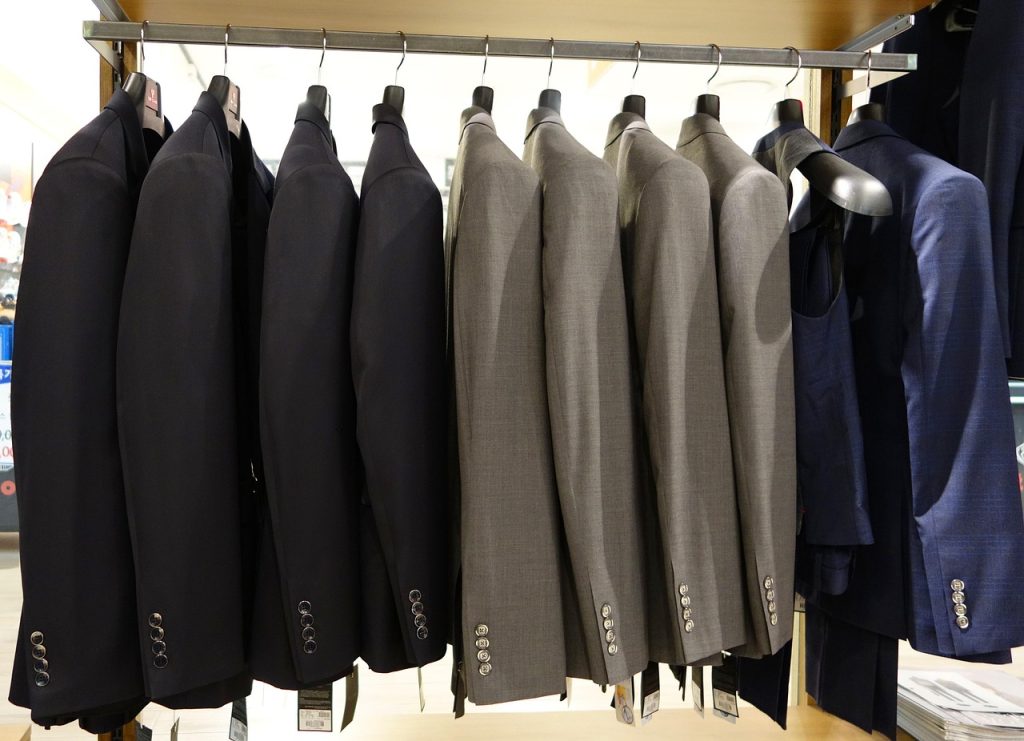 Clothes hanging on a retail rack in a small store.
